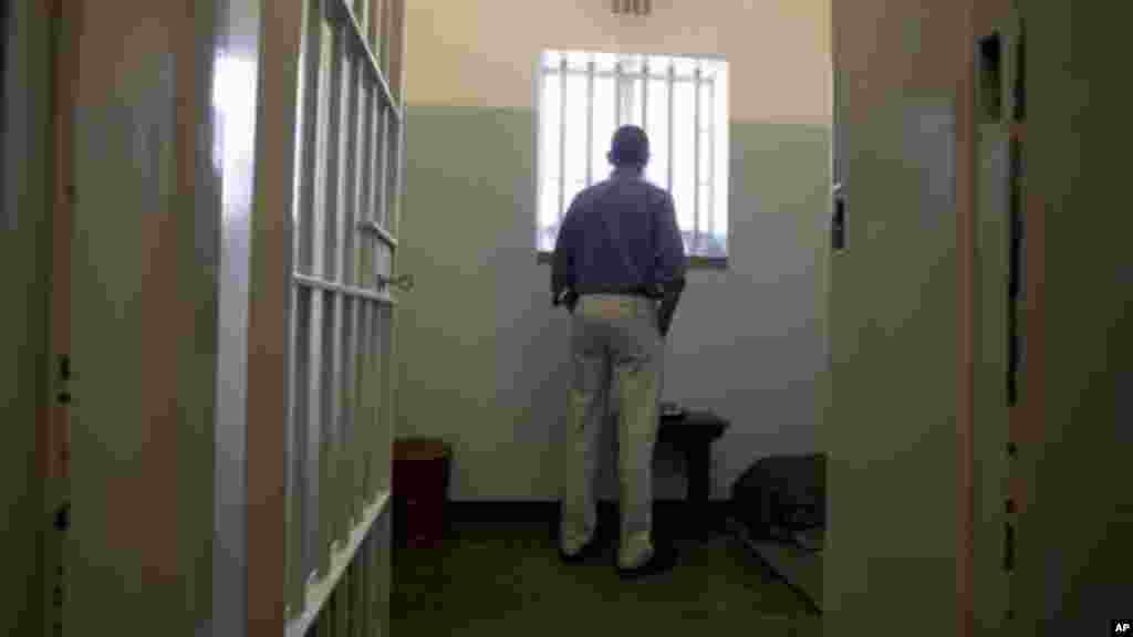 Barack Obama looks out from Mandela's former cell No. 5, on Robben Island, South Africa.