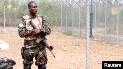 A member of the security forces stands guard at the airport as Ivory Coast Minister of Defense Alain-Richard Donwahi arrives to speak with mutinous soldiers in Bouake, Ivory Coast, Jan. 13, 2017.