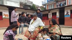 People take refuge at a school after a 7.9-magnitude earthquake struck, causing some buildings to collapse, in Kathmandu, Nepal, April 25, 2015.