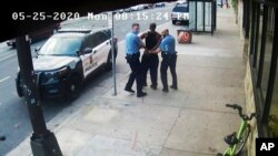FILE - This image from video shows Minneapolis police Officers Thomas Lane, left and J. Alexander Kueng, right, escorting George Floyd, center, to a police vehicle outside Cup Foods in Minneapolis, on May 25, 2020. 
