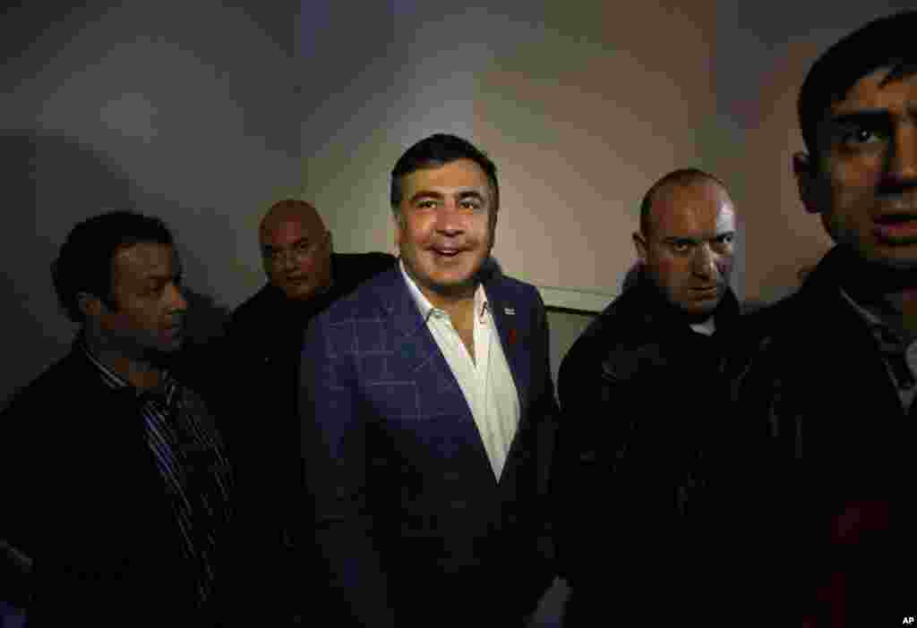 Surrounded by bodyguards, outgoing Georgian President Mikhail Saakashvili walks up a stairwell to his apartment after casting his vote during the presidential election in Tbilisi, Oct. 27, 2013.