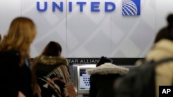 People stand in line at a United Airlines counter at LaGuardia Airport in New York, March 15, 2017. A dog died on a United Airlines plane after a flight attendant ordered its owner to put the animal in the plane's overhead bin.