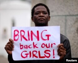 A protester holds a sign during a march in support of the girls kidnapped in Nigeria by members of Boko Haram, in Cape Town, May 8, 2014.