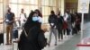 FILE - Travelers wearing masks walk at Jomo Kenyatta International Airport in Nairobi, Aug. 1, 2020. Kenyan officials have raised suspicions over the deaths of 89 Kenyans, most of them domestic workers, in Saudi Arabia.