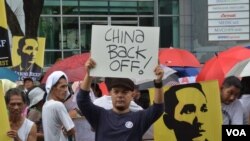 菲律宾人6月12日在中国驻马尼拉领事馆前示威，有人举着的标语牌上写着：中国，撤回去。