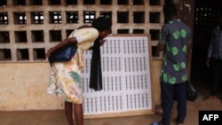 A voter looks at an electoral list outside a polling station in Agoe neighborhood in Lome, Togo, Dec. 20, 2018, during the legislative elections. President Faure Gnassingbe's party won most seats in parliamentary elections, according to provisional results, Dec. 24, 2018.