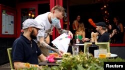 A diner has a lunch outside a restaurant in Didsbury, as the 'Eat Out to Help Out' scheme continues, amid the coronavirus disease (COVID-19) outbreak, in Manchester, Britain, August 10, 2020. REUTERS/Jason Cairnduff
