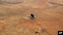 Farmer Lu Keshuang turns the soil of his drought-affected field located 80 kilometres north of Beijing. The drought could impact world wheat prices.