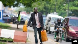 FILE - A man sells black market fuel on the street in Lagos, Nigeria, Tuesday, May 30, 2023. Nigerian President Bola Tinubu has scrapped a decadeslong government-funded subsidy that has helped reduce the price of gasoline, leading to long lines at fuel stations. 