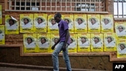 A man walks past election posters for incumbent President Yoweri Museveni in Kampala on Feb. 11, 2016.