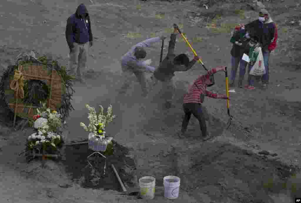 Workers bury 86-year-old Gabina Salgado Husca, who died of complications related to the COVID-19, in the Valle de Chalco municipal cemetery on the outskirts of Mexico City, Nov. 18, 2020.