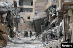 Fighters from Syrian Democratic Forces (SDF) walk together along a damaged street in Raqqa, Syria, Sept. 16, 2017.