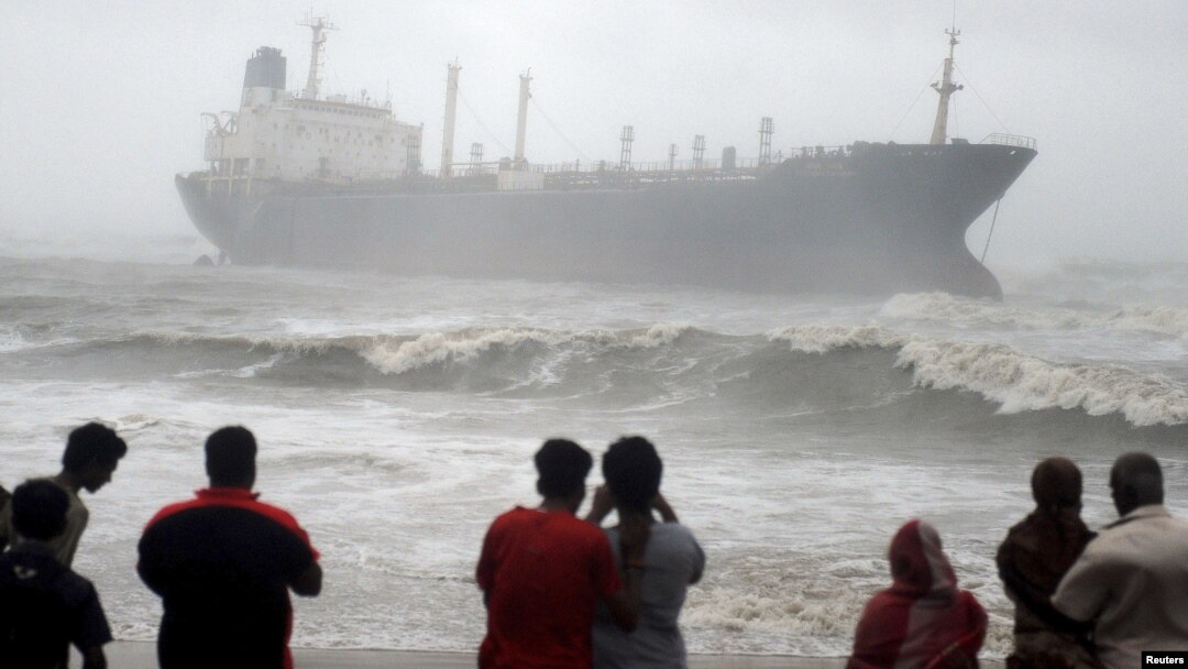 Warga menyaksikan kapal Pratibha Cauvery, yang kandas akibat hantaman topan Nilam di pantai Teluk Benggala, Chennai, India selatan (31/10). 