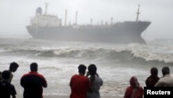 Warga menyaksikan kapal Pratibha Cauvery, yang kandas akibat hantaman topan Nilam di pantai Teluk Benggala, Chennai, India selatan (31/10). 