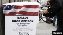 Seorang warga di Denver, Colorado, memasukkan kertas suara pada pemilu yang diadakan lebih awal (25/10). (Reuters/Rick Wilking)