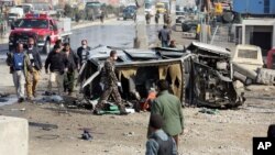 Afghan security forces inspect a British embassy vehicle which was targeted in a suicide attack in Kabul, Afghanistan, Nov. 27, 2014. 