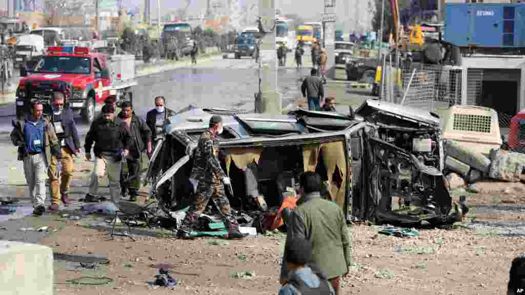 Afghan security forces inspect a British embassy vehicle which was targeted in a suicide attack in Kabul, Afghanistan, Nov. 27, 2014. 