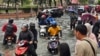 Motorists cross a flooded street after heavy monsoon rains in downtown Kota Bharu, Kelantan, Malaysia, on Nov. 29, 2024.