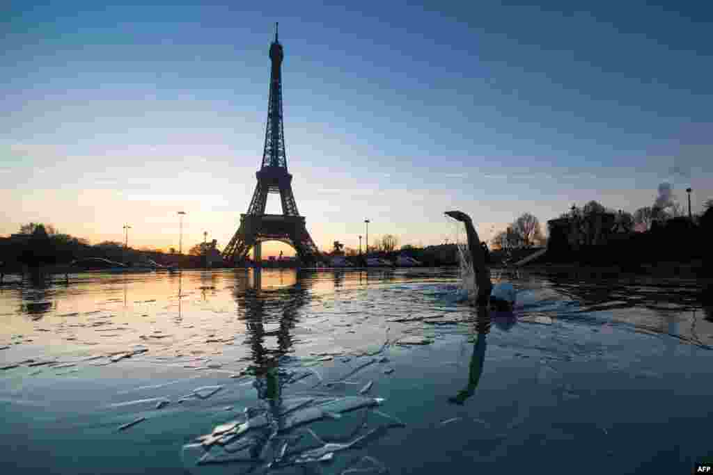 A man swims in the frozen water of the Trocadero fountain in front Eiffel Tower, in Paris, France.