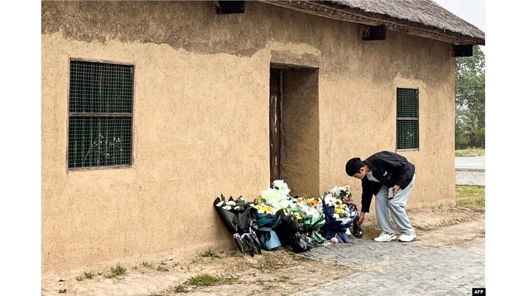 A man places flowers in front of the former house of former Chinese premier Li Keqiang in Dingyuan county, Chuzhou city, in China's eastern Anhui province on Oct. 27, 2023.