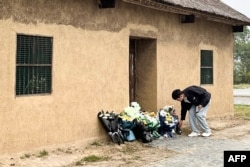 A man places flowers in front of the former house of former Chinese premier Li Keqiang in Dingyuan county, Chuzhou city, in China's eastern Anhui province on Oct. 27, 2023.