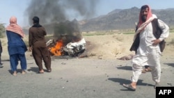 Pakistani local residents gather around a burning vehicle hit by a U.S. drone strike, May 21, 2016. Afghan Taliban Mullah Akhtar Mansoor was the target of the drone near Dalbandin, Baluchistan, Pakistan.