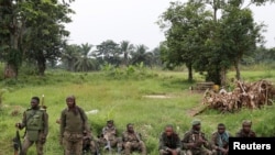 FILE - Armed Forces of the Democratic Republic of the Congo (FARDC) soldiers rest next to a road after Islamist rebel group Allied Democratic Forces (ADF) attacked an area around Mukoko village, North Kivu province, DRC, Dec. 11, 2018. 
