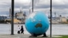 Transeúntes pasan frente a una escultura de la Tierra en el Theas's Park en Tacoma, Washington, en la costa oeste de EE.UU. el 21 de abril de 2020.