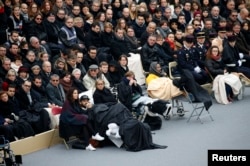 People wounded in the Paris attacks and family members attend a ceremony to pay a national homage to the victims of the Paris attacks at Les Invalides monument in Paris, France, Nov. 27, 2015.