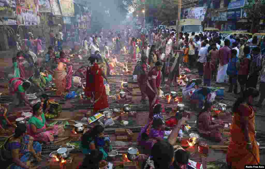 Devotees prepare ritual rice dishes to offer to the Hindu Sun God as they attend Pongal celebrations at a slum in Mumbai, India.