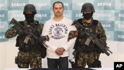 Mexican Marines link arms with Sergio Antonio Mora Cortes, alias "El Toto," as they present him to the press after his arrest in Mexico City, Feb. 28, 2011