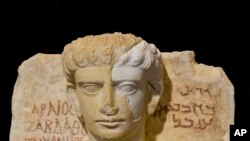 A limestone male bust dated between the 2nd and the 3rd century A.D. that was damaged during the Islamic State occupation of the Syrian city of Palmyra, is shown during a press conference in Rome, Feb. 16, 2017.