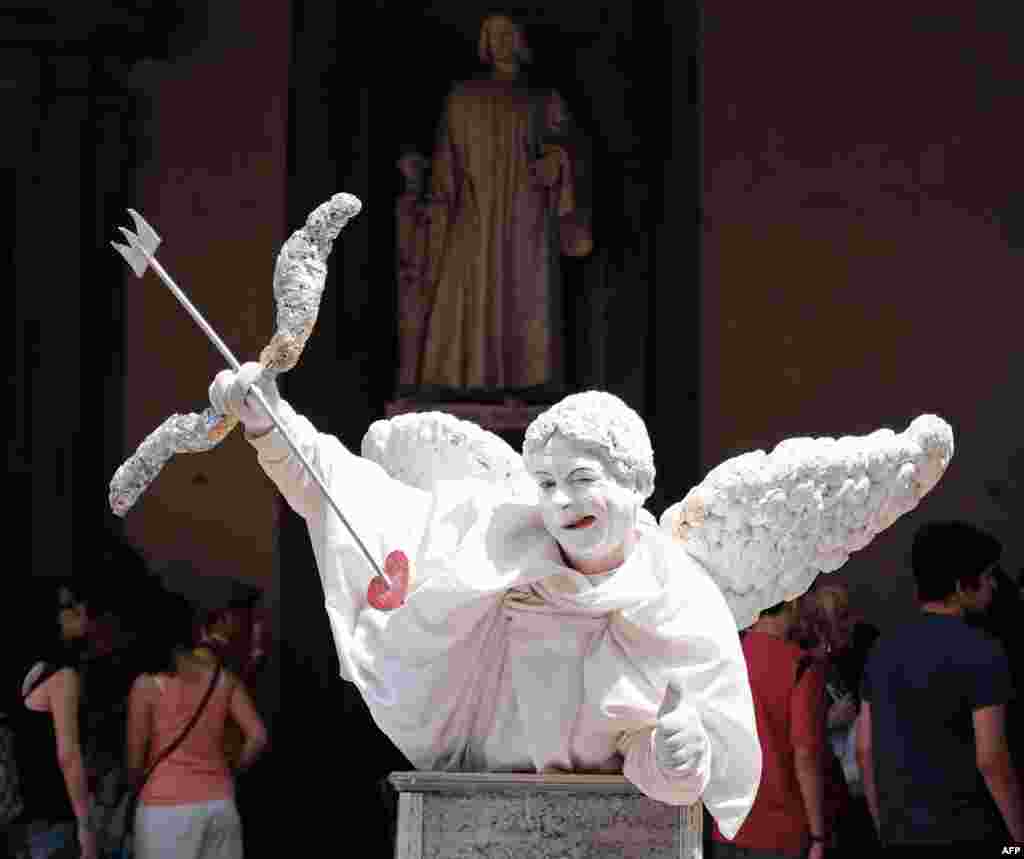A street artist dressed as an angel performs under the Uffizi Gallery in Florence, Italy.