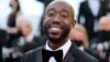 Le rappeur américain Freddie Gibbs sourit en arrivant pour la projection du film "Tre Piani" (Trois étages) à la 74e édition du Festival de Cannes dans le sud de la France, le 11 juillet 2021.