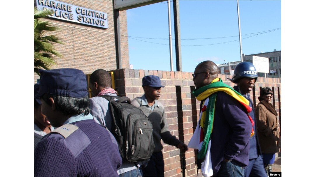 Zimbabwean Pastor Evan Mawarire (2nd R), who organized a 'stay at home' anti-government protest last week, arrives at the Harare Central Police station in Zimbabwe, July 12, 2016.