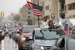 People in their vehicles protest against excessive quarantine orders from Michigan Governor Gretchen Whitmer around the Michigan State Capitol in Lansing, Michigan on April 15, 2020.