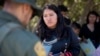 Una migrante de México habla con un agente de la Patrulla Fronteriza poco antes de ser transportada en una camioneta para ser procesada para el asilo, el miércoles 5 de junio de 2024, cerca de Dulzura, California, EEUU. 