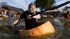 Competitors paddle in giant hollowed out pumpkins at the yearly pumpkin regatta in Kasterlee, Belgium, Oct. 27, 2024. 