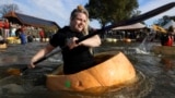 Competitors paddle in giant hollowed out pumpkins at the yearly pumpkin regatta in Kasterlee, Belgium, Oct. 27, 2024. 