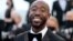 Le rappeur américain Freddie Gibbs sourit en arrivant pour la projection du film "Tre Piani" (Trois étages) à la 74e édition du Festival de Cannes dans le sud de la France, le 11 juillet 2021.