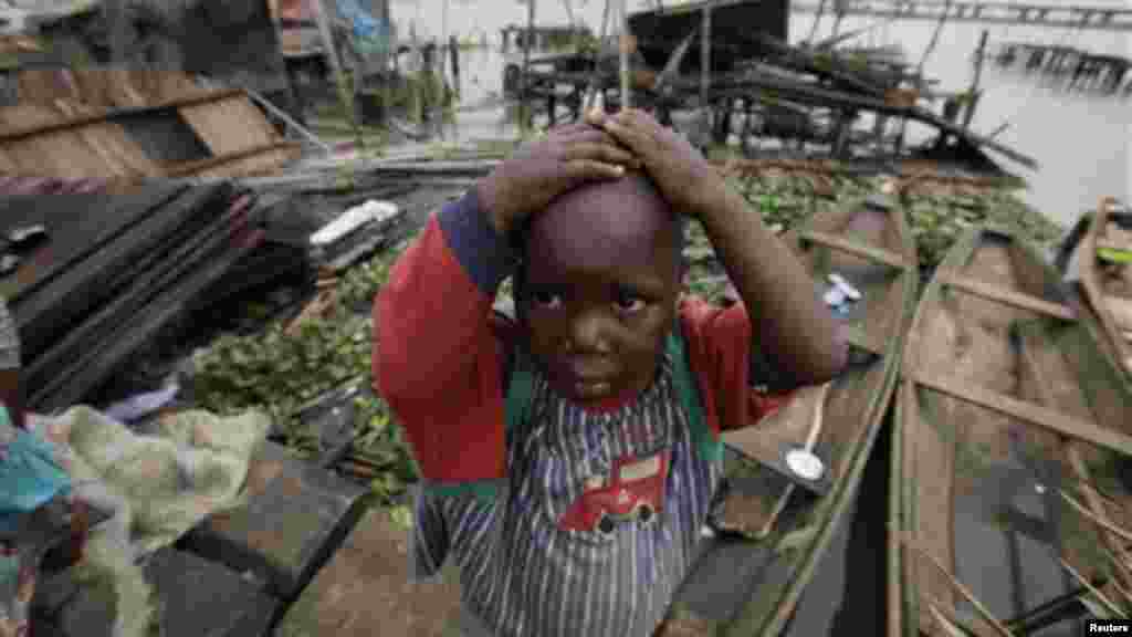 A child stand in front of his demolished illegal stilt house in Legas.