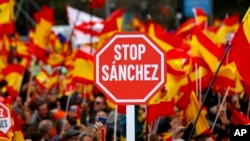 Demonstrators hold banners and Spanish flags during a protest in Madrid, Spain, Feb.10, 2019. 