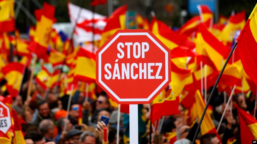 Demonstrators hold banners and Spanish flags during a protest in Madrid, Spain, Feb.10, 2019. 