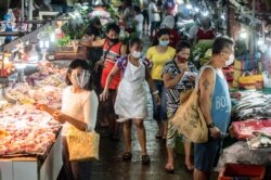 People wearing masks shop for fresh food at a market in Manila on Aug. 6, 2020.