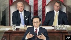 South Korean President Lee Myung-bak speaks to a joint meeting of Congress as Vice President Joe Biden (L) left, and Speaker of the House John Boehner (R) look on at the Capitol in Washington, October 13, 2011.