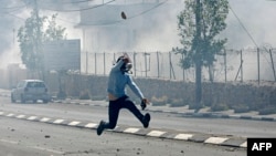 Un Palestinien lance une pierre lors d'affrontements avec les forces de sécurité israéliennes dans la ville de Bethléem, Cisjordanie, 31 mars 2018.