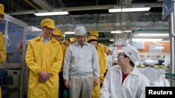 CEO Apple Tim Cook (kiri) dalam kunjungan ke Taman Teknologi Foxconn Zhengzhou di Henan, Tiongkok. (Foto: Handout)