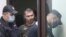 Alexander Popov, arrested on suspicion of murdering American student Catherine Serou, is escorted by police officers into a courtroom in the city of Gorodets, north-west of Nizhny Novgorod, Russia, June 20, 2021.
