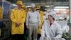 Apple Chief Executive Officer Tim Cook (L) visits the iPhone production line at the newly built Foxconn Zhengzhou Technology Park in Zhengzhou, Henan province, China, March 28, 2012 handout photo.