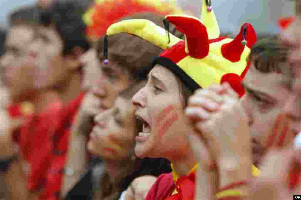 Soccer fans react as they watch the World Cup group H soccer match between Spain and Switzerland on a large screen outside the Santiago Bernabeu stadium in Madrid, on Wednesday, June 16, 2010. Switzerland won 1-0. Millions of people worldwide are follow